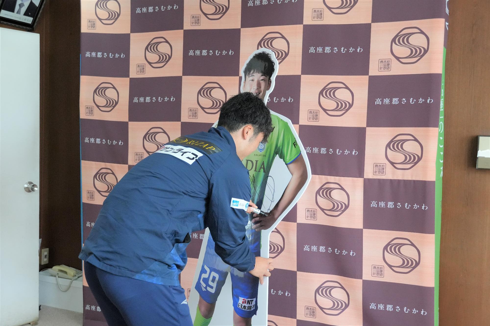 サインを書く鈴木章斗選手