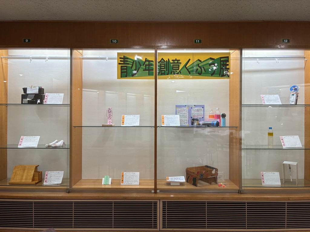 展示作品が木製の棚に展示されている様子の写真