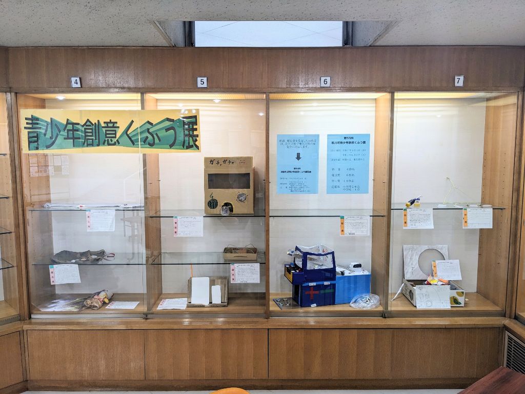 展示作品が木製の棚に展示されている様子の写真